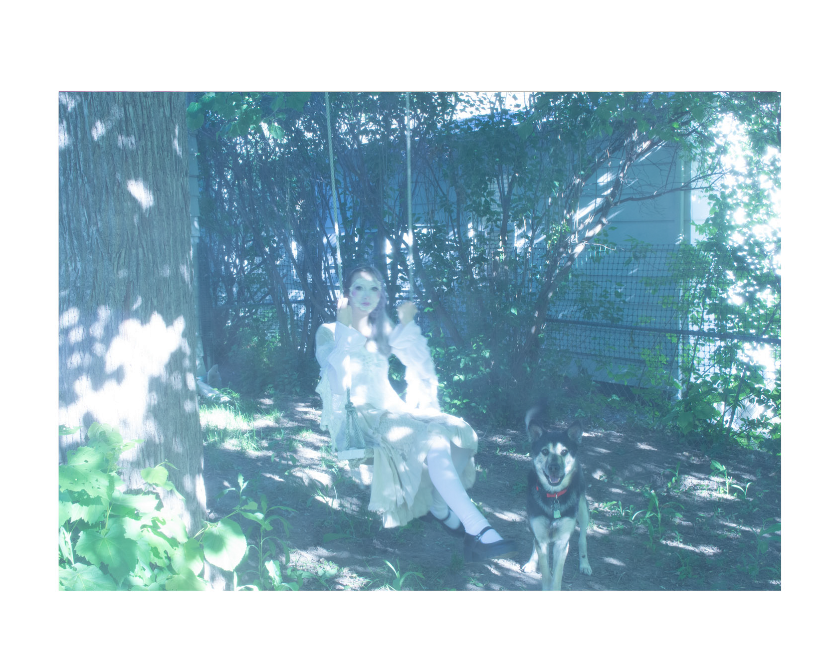 A woman with white face paint and pink makeup in a white dress, swinging in a yard next to a dog.